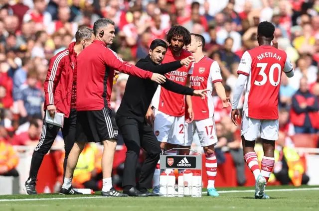 Mikel Arteta talks to the Arsenal players during a break in the game against Manchester United