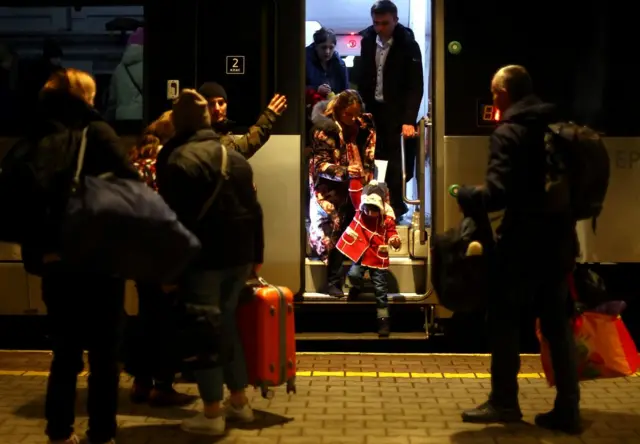 Ukrainian refugees disembark a train