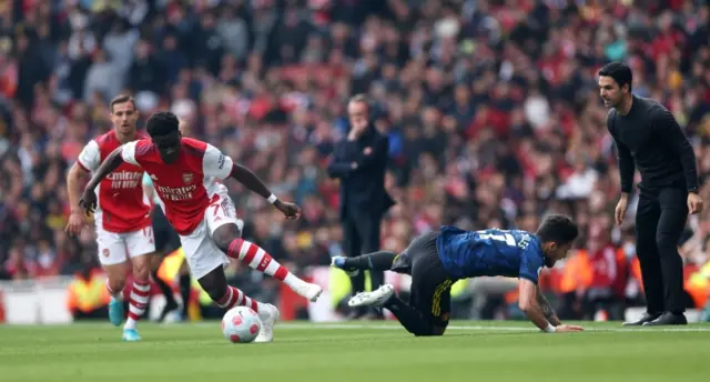 Mikel Arteta looks on as Bukayo Saka challenges Alex Telles