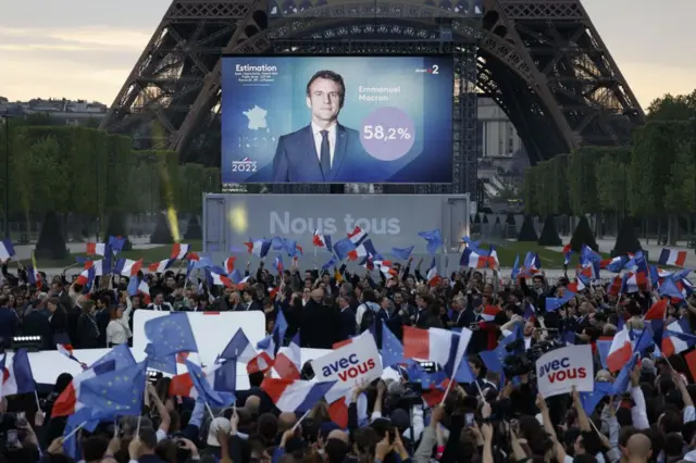 Macron supporters waving flags in front of the Eiffel Tower