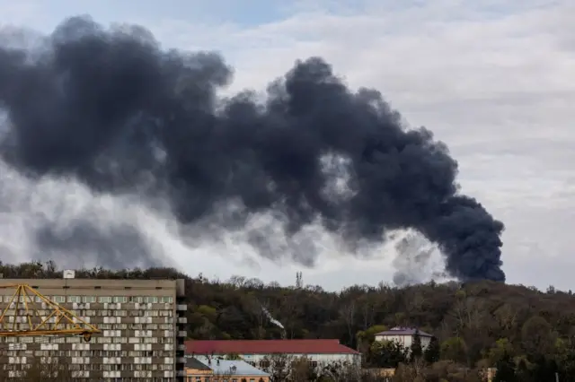 Smoke seen over trees and buildings in Lviv