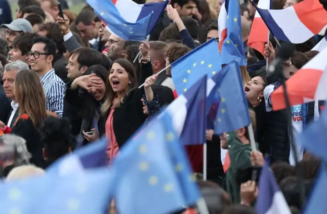 Macron supporters celebrate and wave French and EU Flags