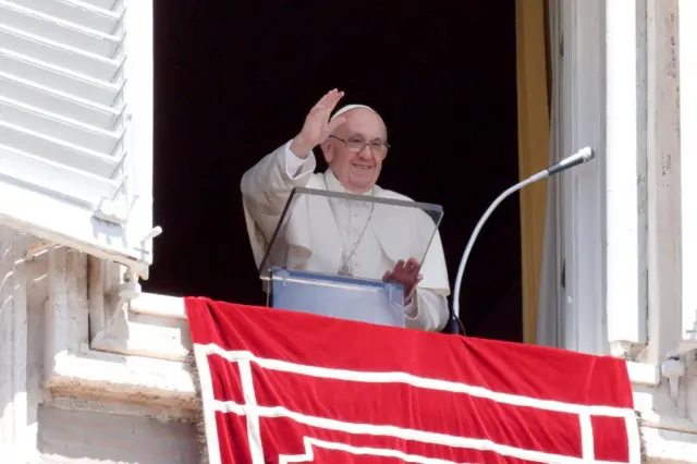 Pope Francis waves from the window of his office overlooking St Peter's Square