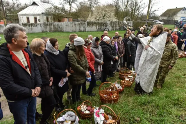 An Orthodox priest blesses worshippers in a village near Kyiv. Photo: 24 April 2022