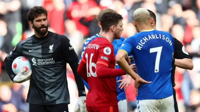 Liverpool and Everton players confront referee Stuart Atwell