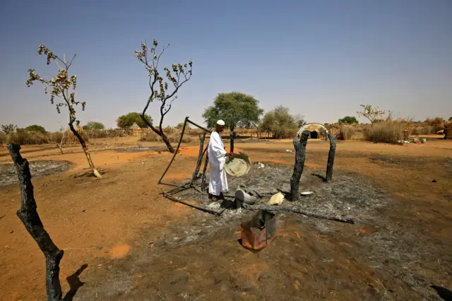 A Sudanese man checks the aftermath of violence in the village of Twail Saadoun, 85 kilometres south of Nyala town, the capital of South Darfur, on February 2, 2021