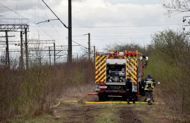 Firefighters work near one of the railway facilities attacked by a Russian missile