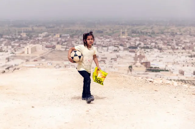 Egyptian girl walking with football in her hand