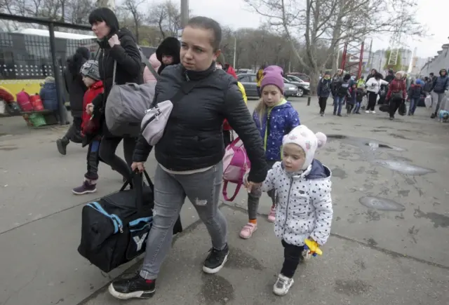 Refugees who came from Mykolayiv city by buses walk in the South Ukrainian city of Odesa, Ukraine