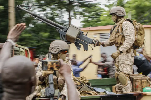 Malian soldiers parade as they arrive by military vehicle at Independence Square in Bamako on August 18, 2020