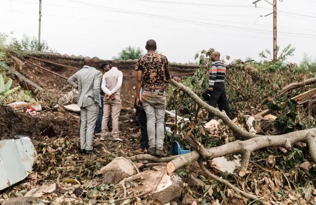 Family members stand on debris of the home destroyed in the recent floods in South Africa