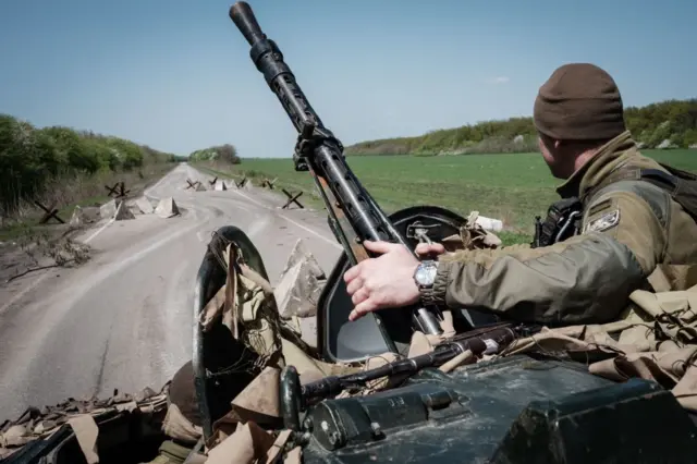 A Ukrainian troop rides an armoured vehicle in eastern Ukraine