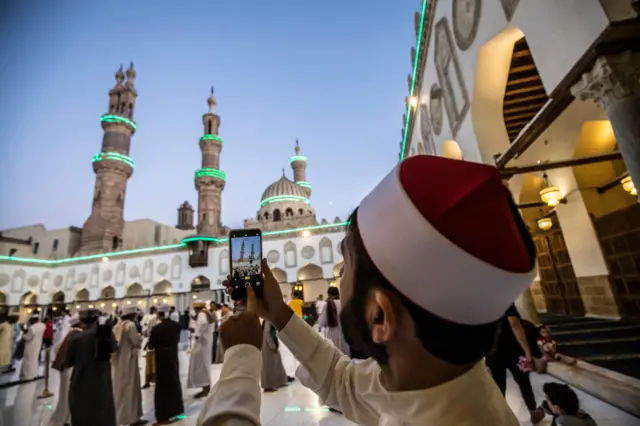 A man takes a photo at a mosque in Cairo, Egypt