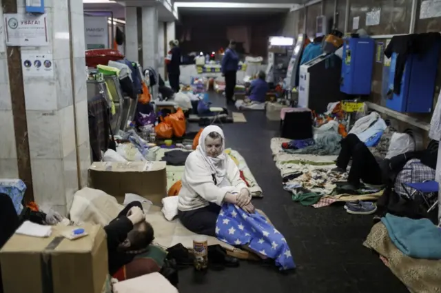 A woman sits on her bedding as residents find shelter from shellings in a metro station, amid Russia"s attack on Ukraine, in Kharkiv