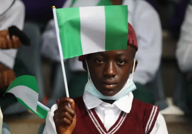 A Schoolboy display the Nigerian flag at the Eagles Square in Abuja