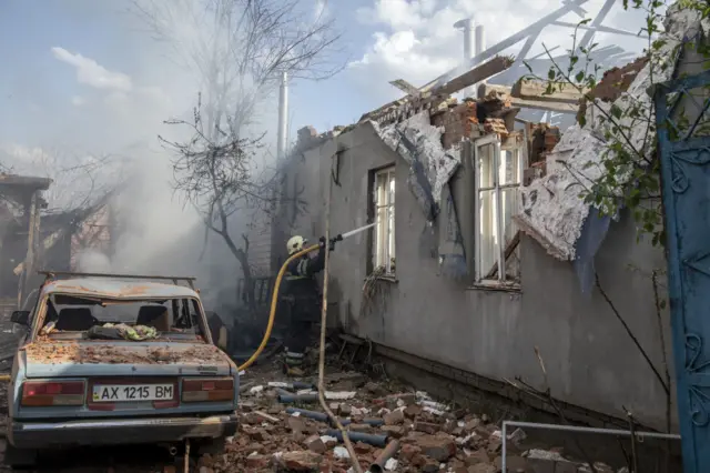 A firefighter in Kharkiv works to extinguish a blaze