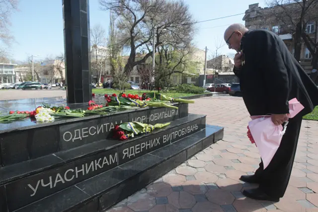 A man lays flowers to a monument of victims of the Chernobyl nuclear power plant in Odessa