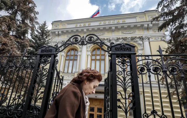 A woman walks past the Bank of Russia