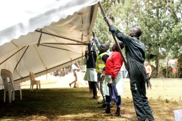 Worker erecting a tent at the Othaya Approved School