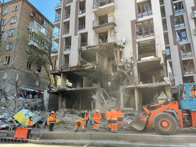 Rescuers attend to a damaged residential building in Kyiv