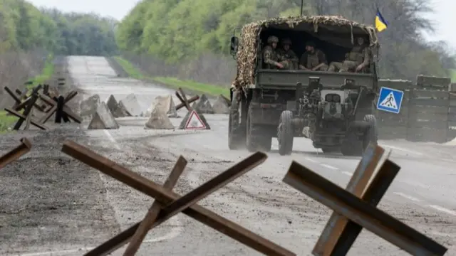 A Ukrainian military vehicle drives to the front line during a fight, amid Russia's invasion in Ukraine, near Izyum