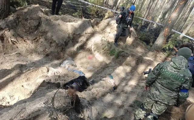 Picture shows bodies in a shallow grave in the village of Motyzhyn
