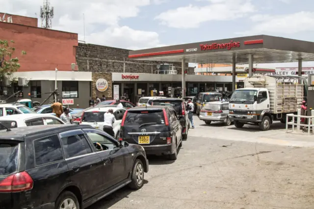 Motorists queue to fuel at a Total gas station