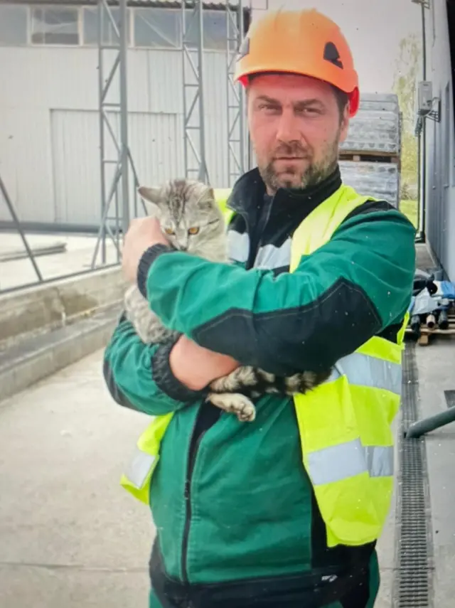 Late Ukrainian welder Oleg Abramov poses with a cat