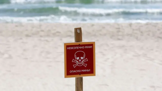 A sign warns of mines along a beach in Odesa