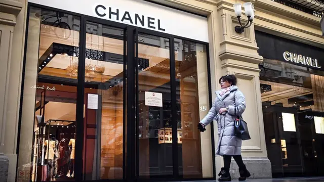 Woman walks past shops in Russia