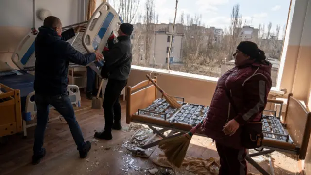 Volunteers and staff clean up the destruction left after the Russians targeted a hospital with a suspected cluster munition on April 04,