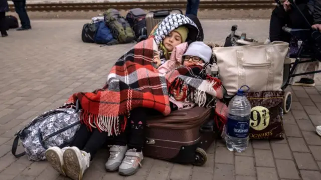 Children lie down on luggage at Kramatorsk central station, 5 April