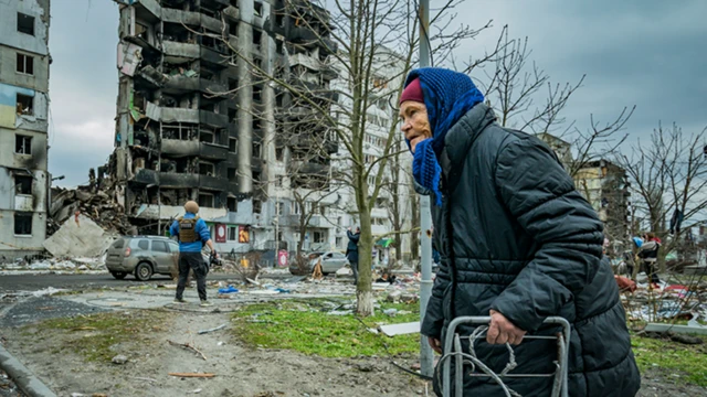 An old woman of Borodyanka passes a nearly totally destroyed building