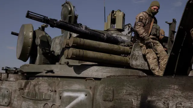 Ukrainian troops on a captured Russian tank