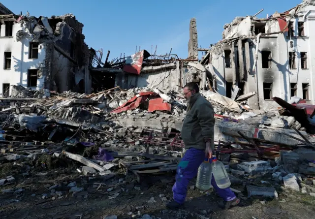 A man carries bottles of drinking water in Mariupol. Photo: 7 April 2022