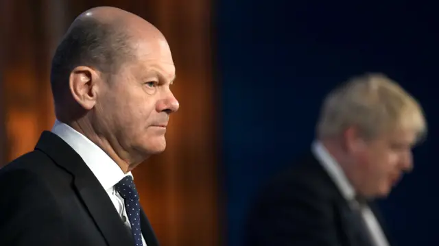 Germany"s Chancellor Olaf Scholz (L) and Britain"s Prime Minister Boris Johnson (R) speak at a press conference in Downing Street in London