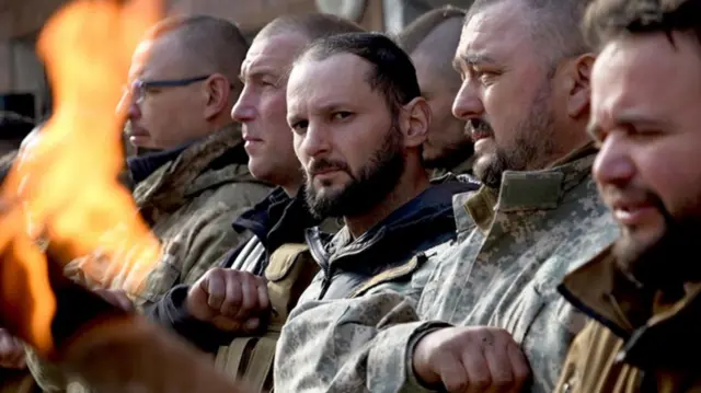 Ukrainian soldiers mourn at a military funeral