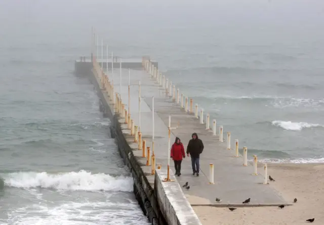 People walk on the Black Sea coast of the city of Odesa on 6 April