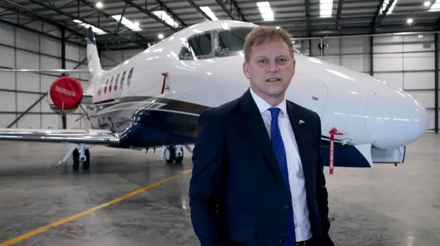 Transport Secretary Grant Shapps standing in front of the jet