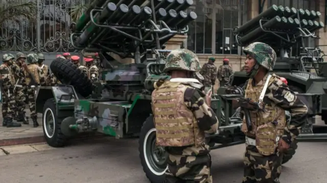 Malagasy soldiers standing by military hardware