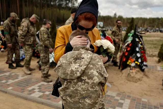 A mother comforts her son as they mourn their husband and father who according to her was a soldier killed by shelling