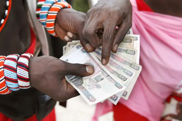 Two men counting Kenyan money