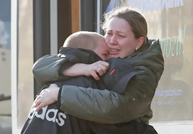 An Azovstal steel plant employee hugs her son