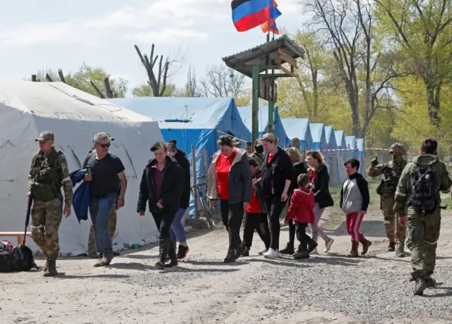 Civilians who left the area near Azovstal steel plant in Mariupol walk at a temporary accommodation centre in Bezimenne