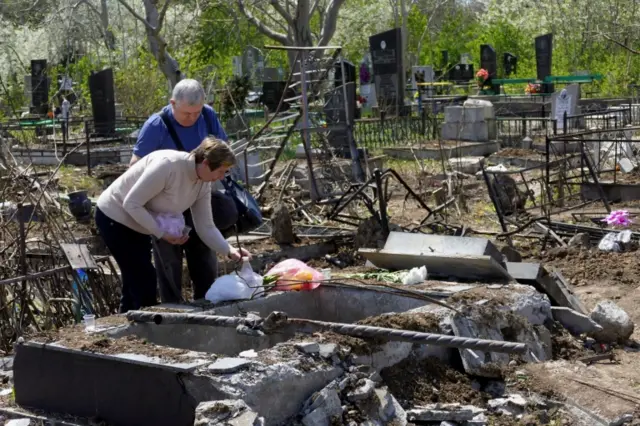 People visit Tairovske cemetery, where 51 graves been damaged and destroyed by a Russian missile strik