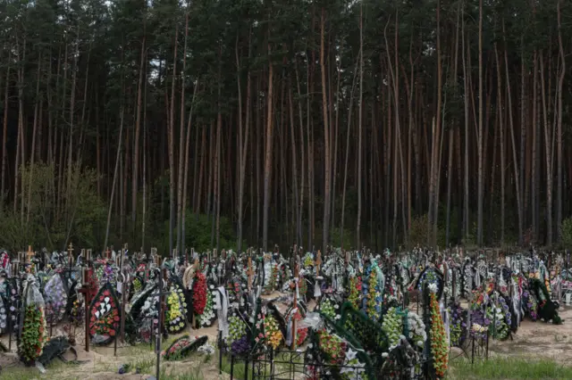 Crosses and floral wreaths are seen in a cemetery in Irpin, outside Kyiv