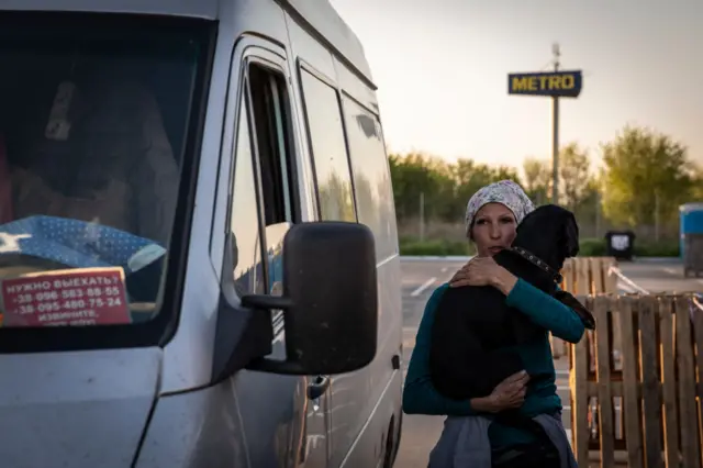 A woman holds her dog as she arrived from Kherson to Zaporizhia, on Sunday.