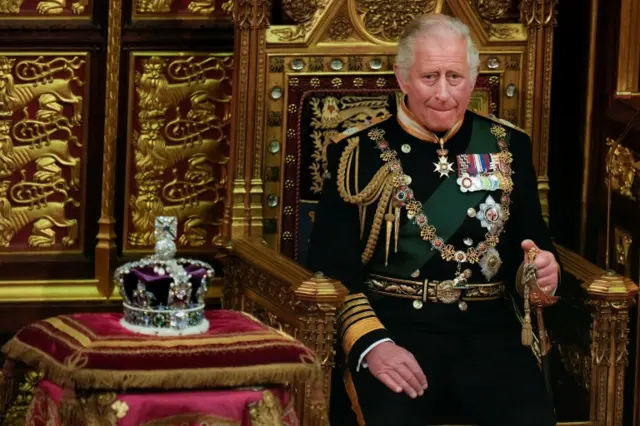 Prince Charles sits next to the Queen"s crown during the State Opening of Parliament