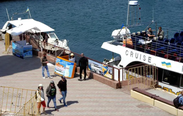 People by a tourist boat in Odesa in May 2021