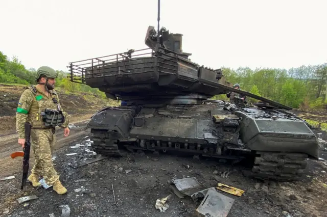 A Ukrainian serviceman walks next to a destroyed Russian bank in the Kherson region